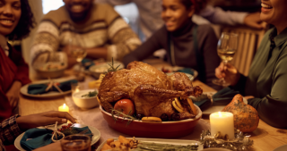 Family enjoying a holiday meal with Turkey and Ham Gift Certificates.